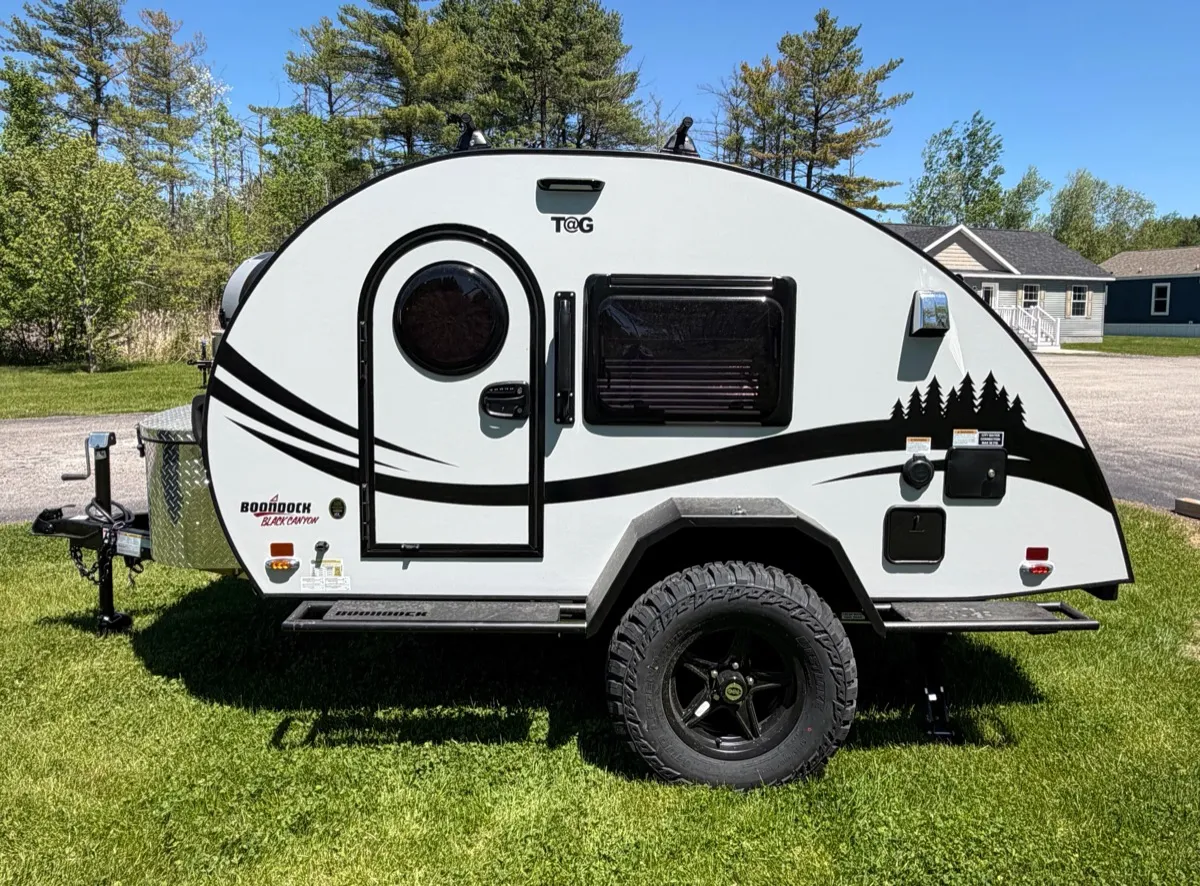 nuCamp TAG XL teardrop trailer parked on grass at Outpost Outfitters